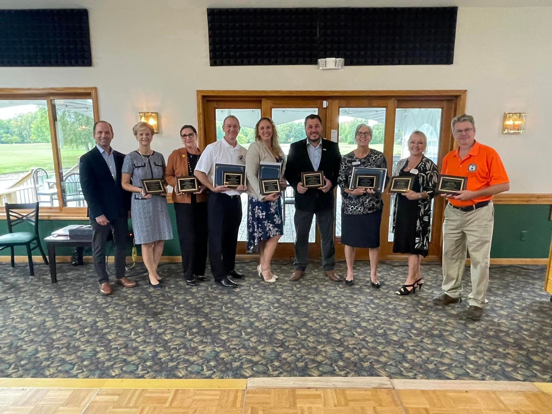 A group of people holding plaques in a room.