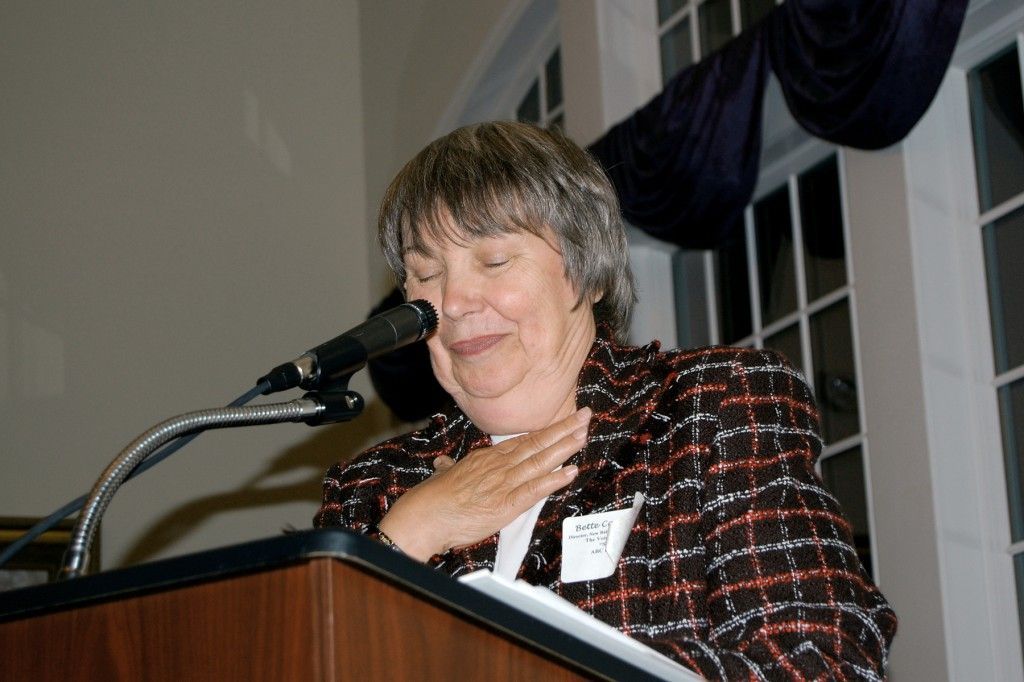 A woman stands at a podium.