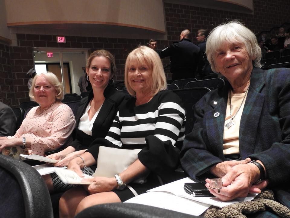 A group of women sitting in a row of seats.
