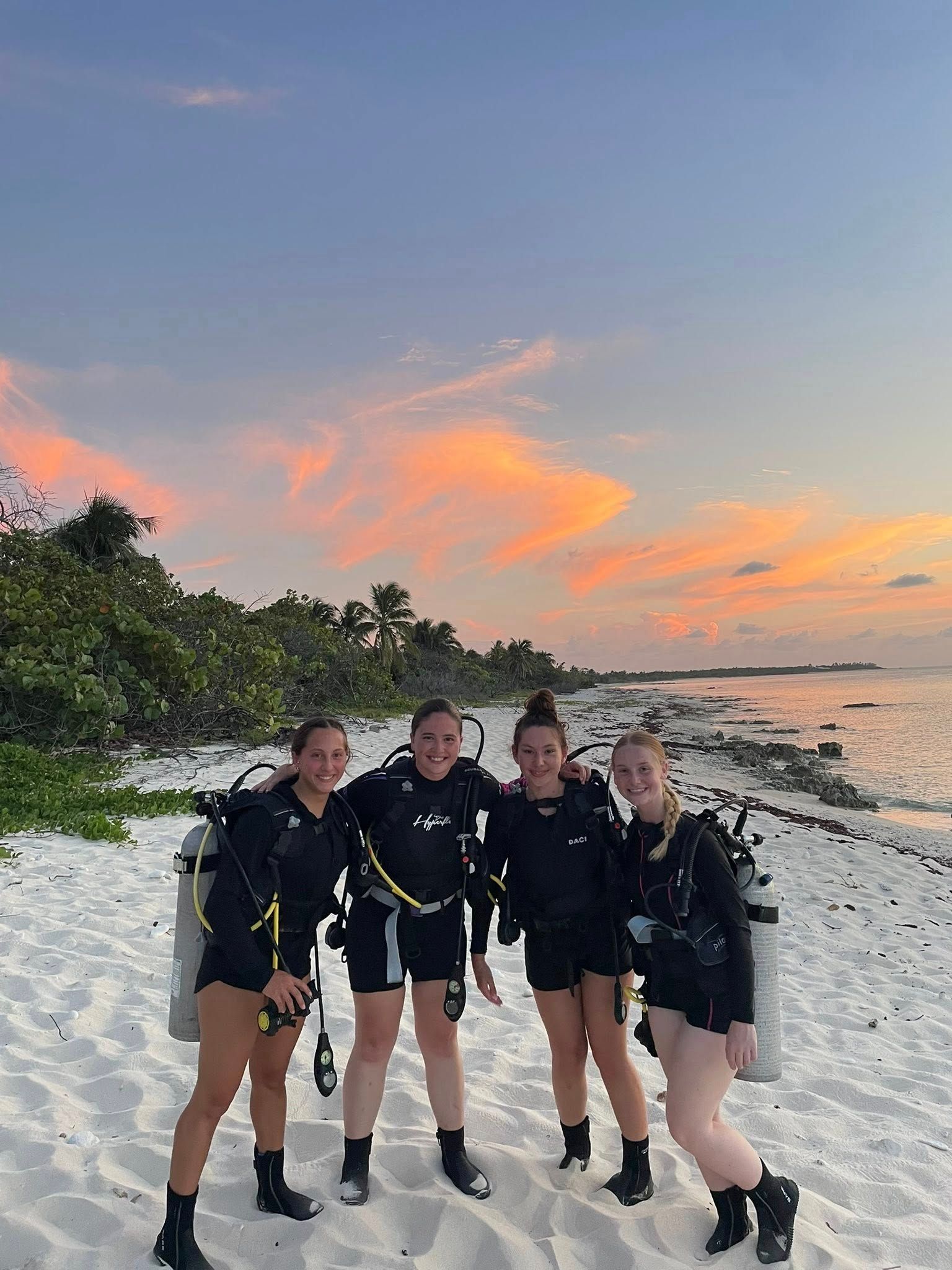 a woman holding a red balloon stands between two men and a woman holding a check.