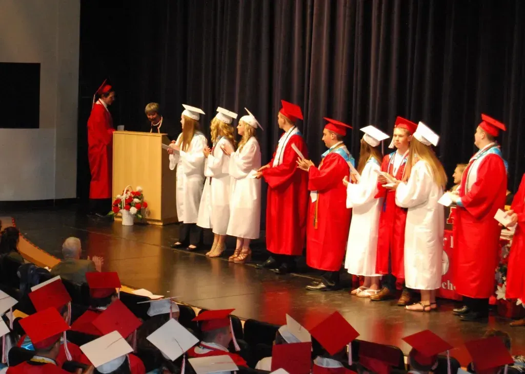 A group of graduates lined up behind a podium.