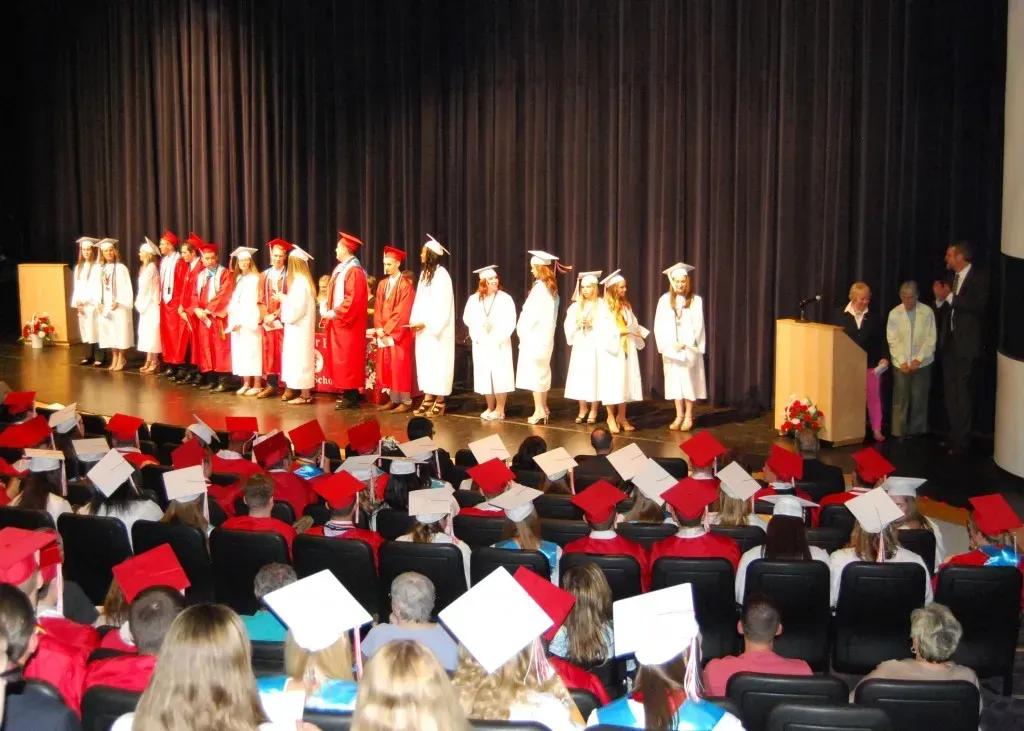 A group of graduates lined up in front of a podium.