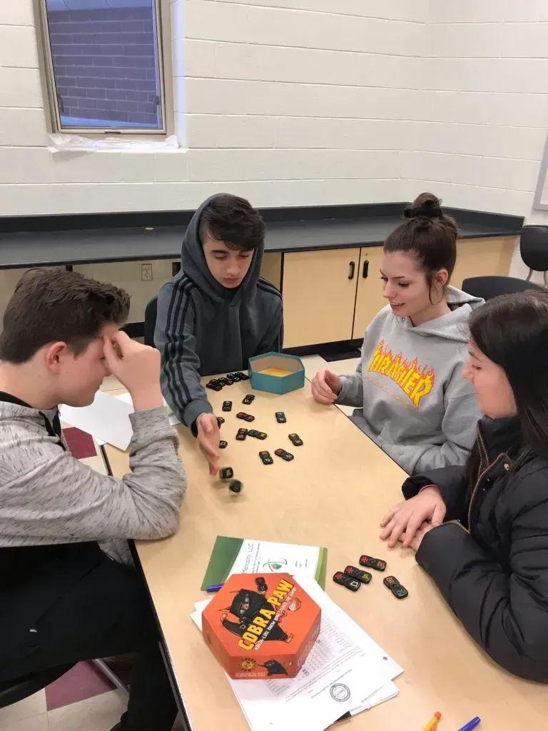 A group of teens playing dominoes.