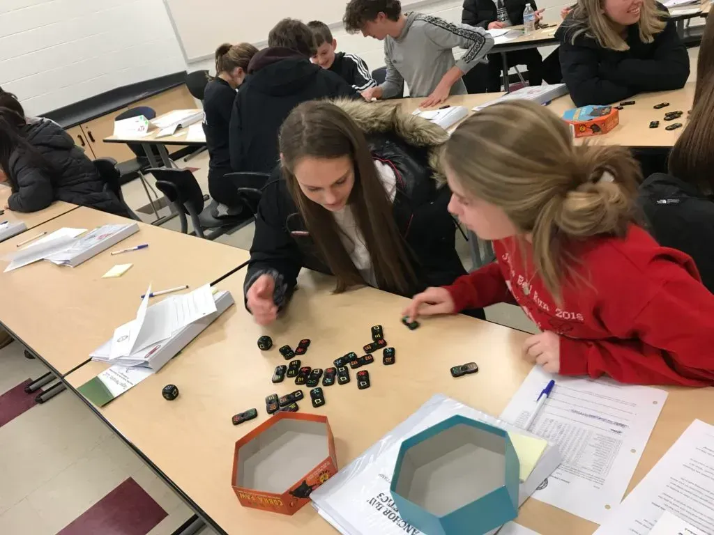 Two teens are playing a game of dominoes.