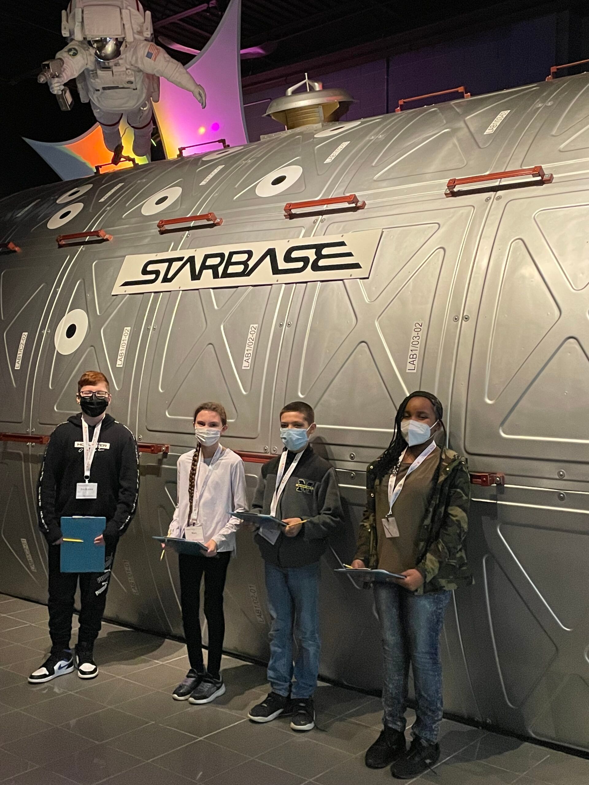 A group of people standing in front of a Starbase sign.
