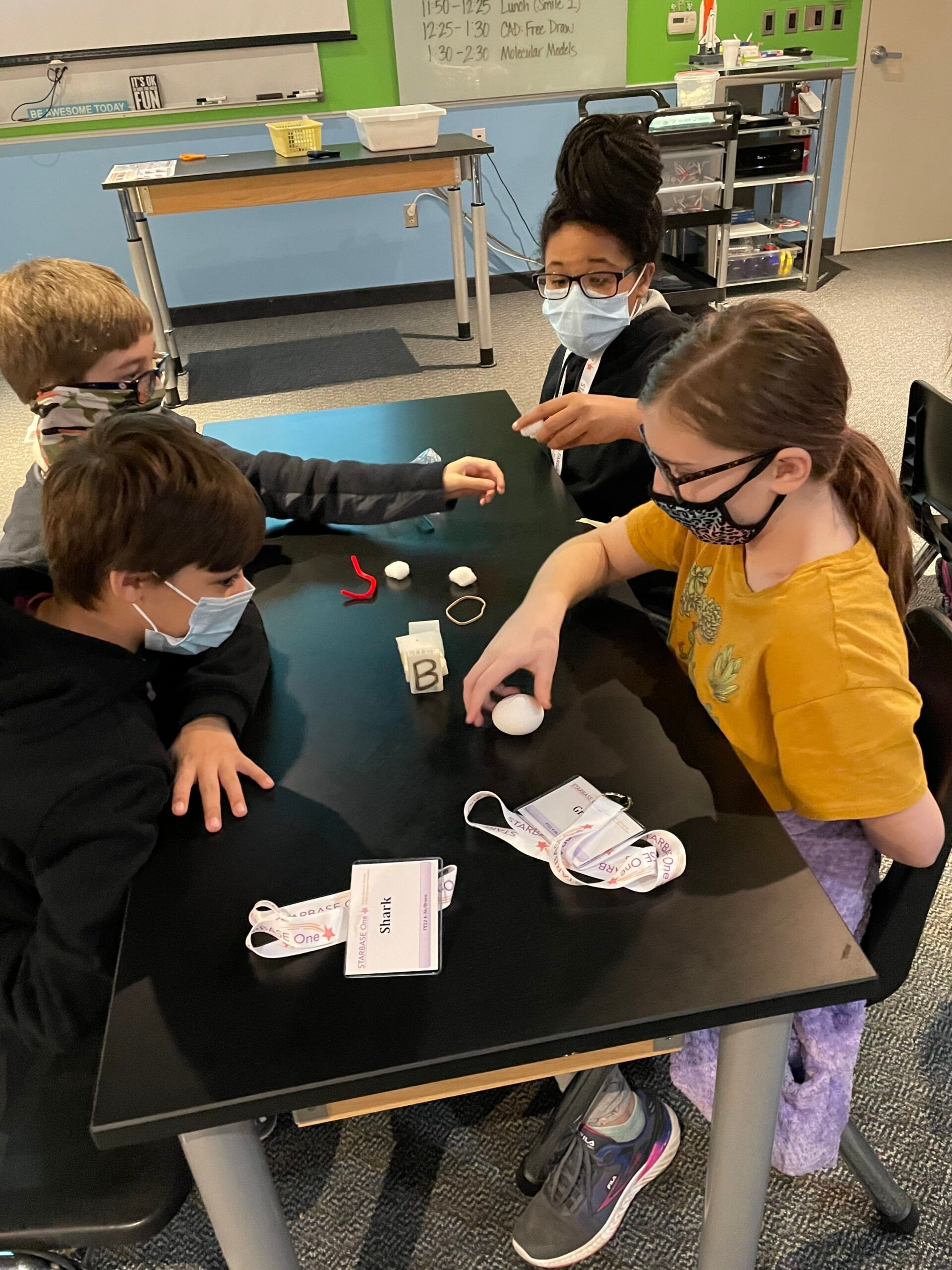 A group of children are sitting at a table playing a game.