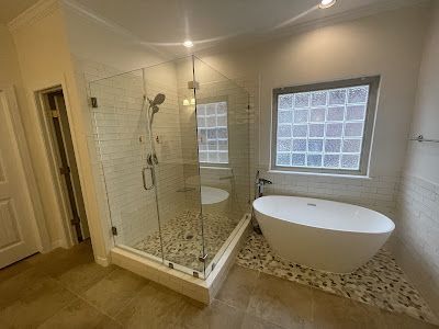 A bathroom with a tub , shower , and window.