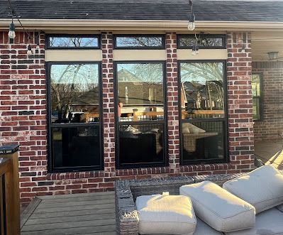 A brick house with a lot of windows and a patio.