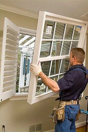 A man is installing a window in a house.