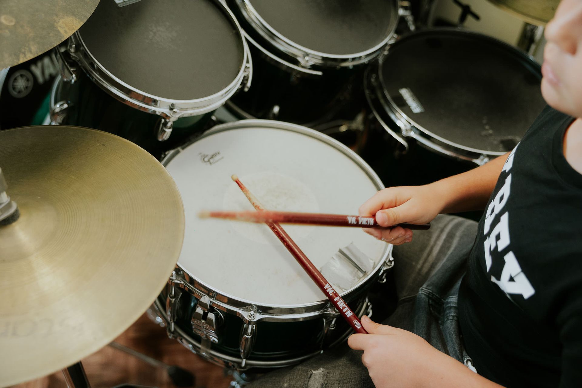 Batterista che colpisce il rullante con le bacchette.