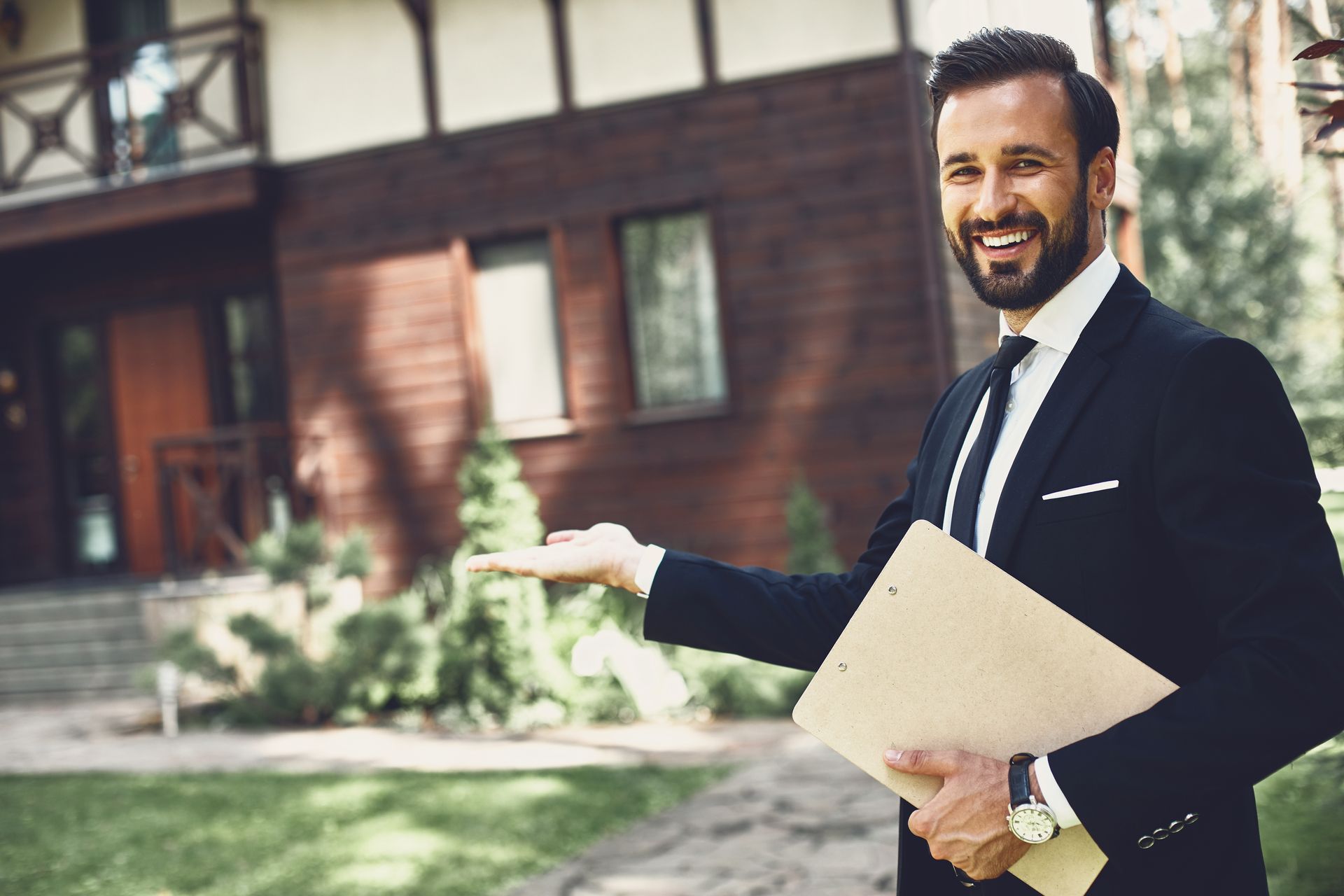 Professional realtor holding clipboard pointing at modern home exterior for property showing.