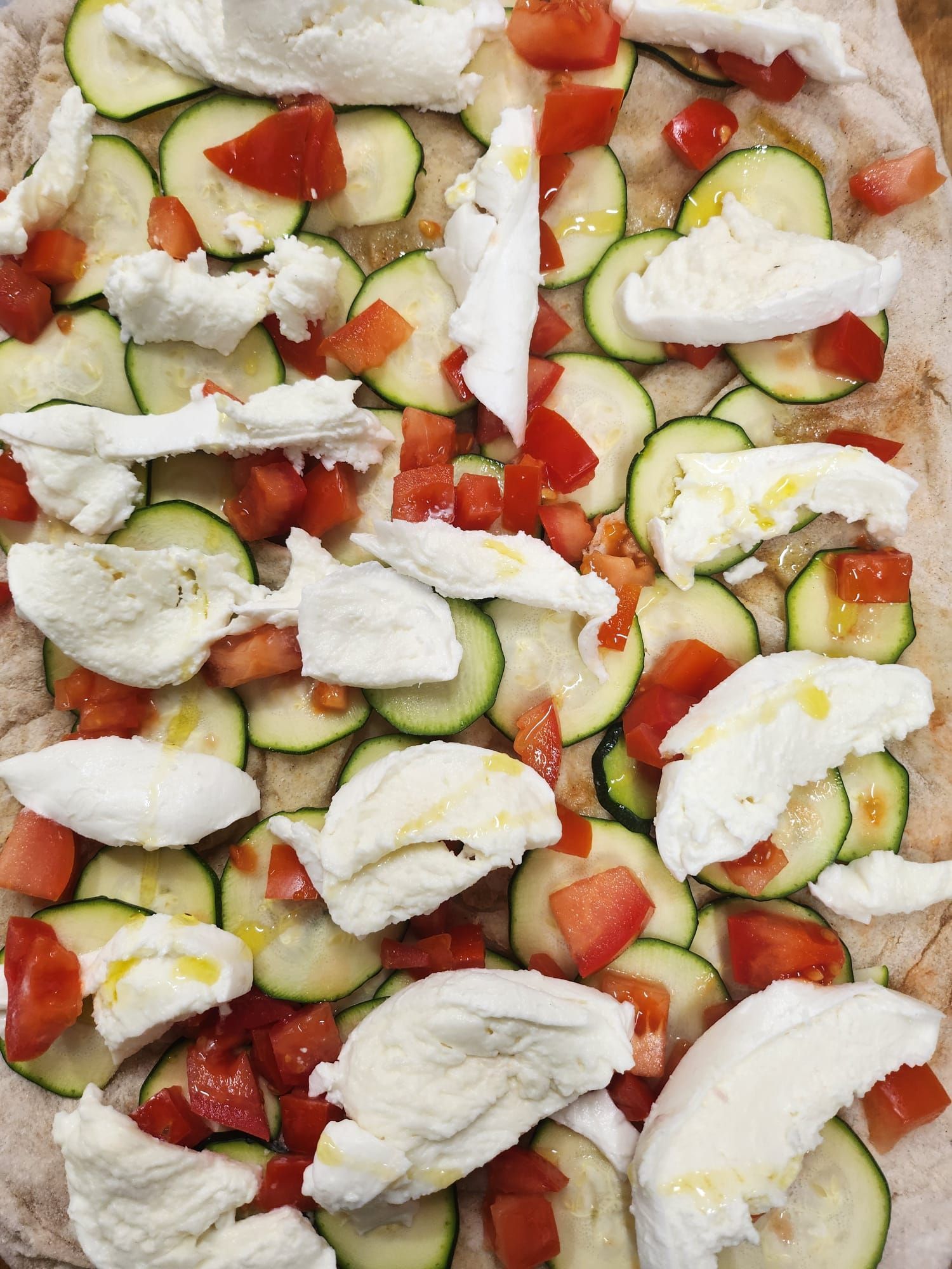 Insalata di verdure crude e mozzarella con fette di cetriolo, pomodori a cubetti e pezzetti di formaggio bianco.