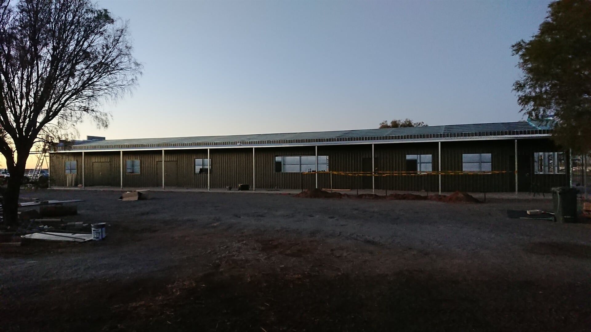 A Large Building With A Lot Of Windows Is Being Built — Alice Sheds & Structures In Ciccone, NT