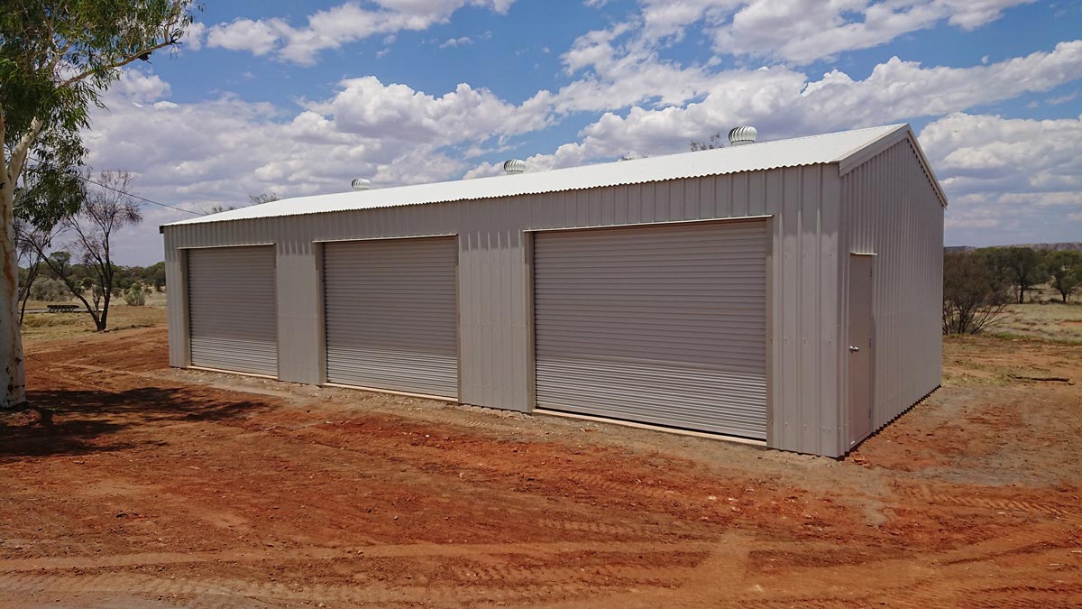 A Large Metal Building Sitting In The Middle Of A Dirt Field — Alice Sheds & Structures In Ciccone, NT