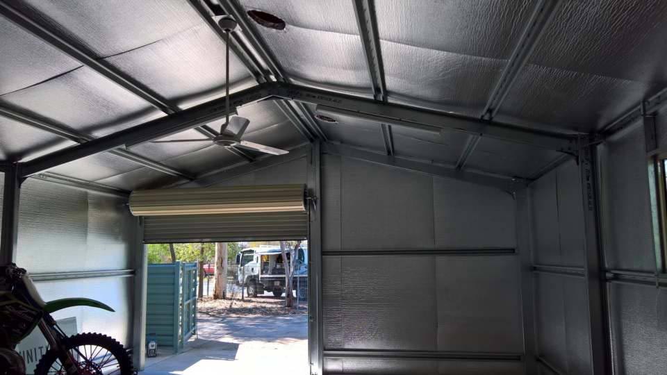 A Motorcycle Is Parked In A Garage With A Ceiling Fan — Alice Sheds & Structures In Ciccone, NT