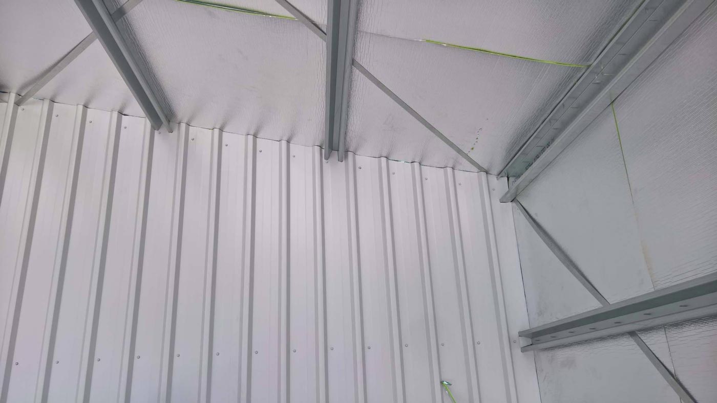 The Inside Of A Metal Building With A White Wall And A Metal Roof — Alice Sheds & Structures In Ciccone, NT