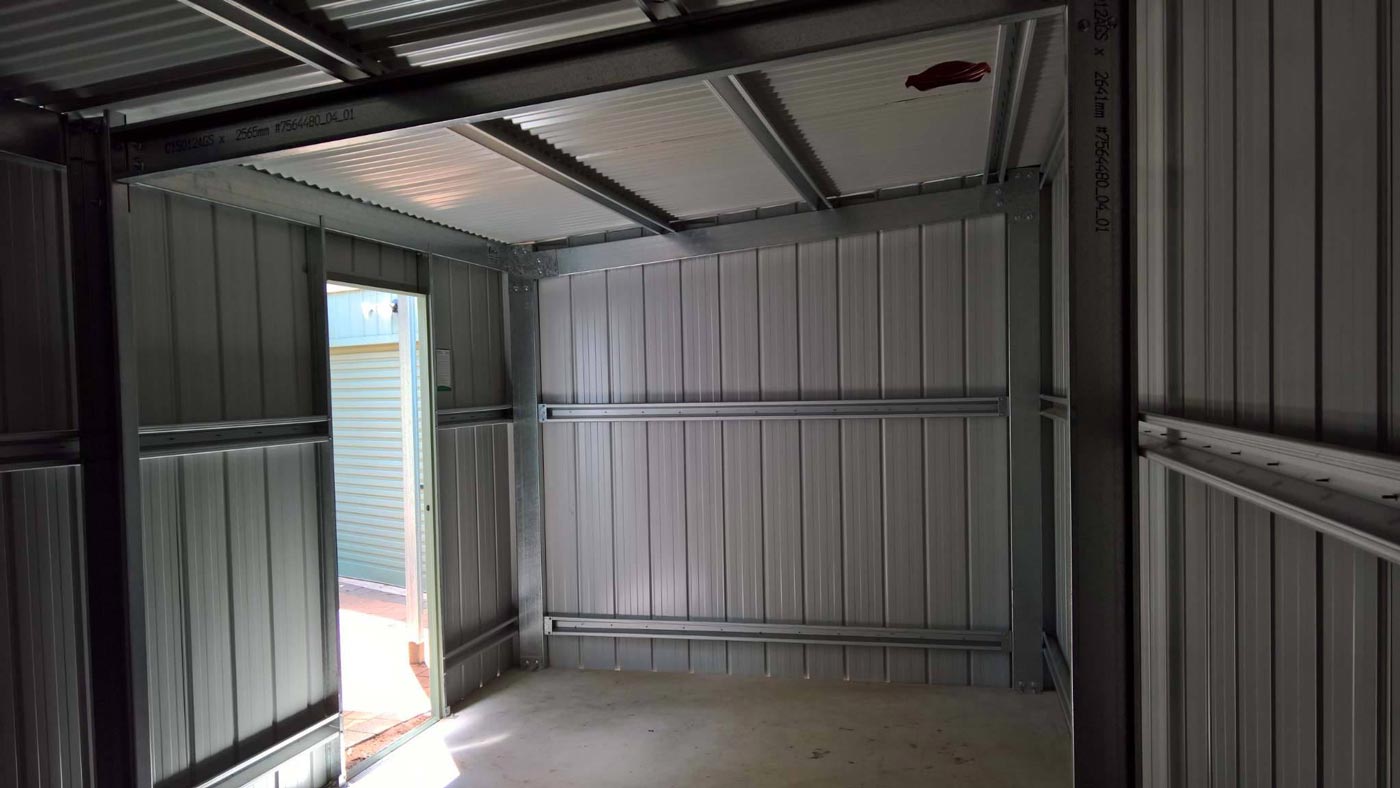 The Inside Of A Metal Garage With A Door Open — Alice Sheds & Structures In Ciccone, NT