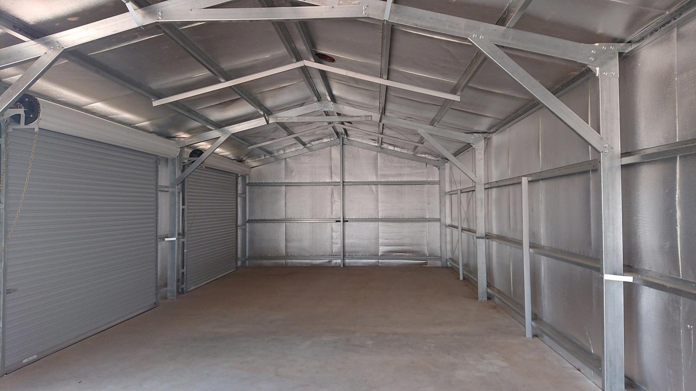 An Empty Metal Garage With A Roof And A Door — Alice Sheds & Structures In Ciccone, NT
