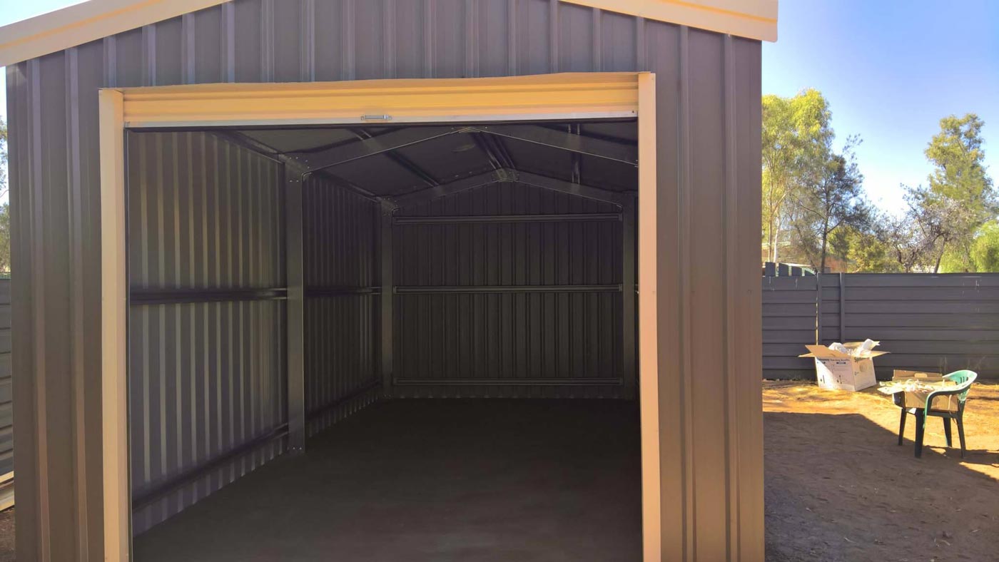 An Empty Garage With The Door Open And A Fence In The Background — Alice Sheds & Structures In Ciccone, NT