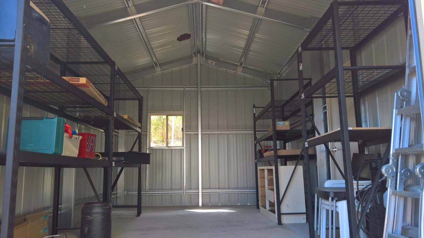 The Inside Of A Metal Shed With Shelves And A Window — Alice Sheds & Structures In Ciccone, NT