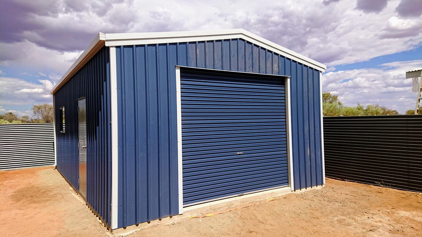 A Blue Shed With A Roller Door — Alice Sheds & Structures In Ciccone, NT