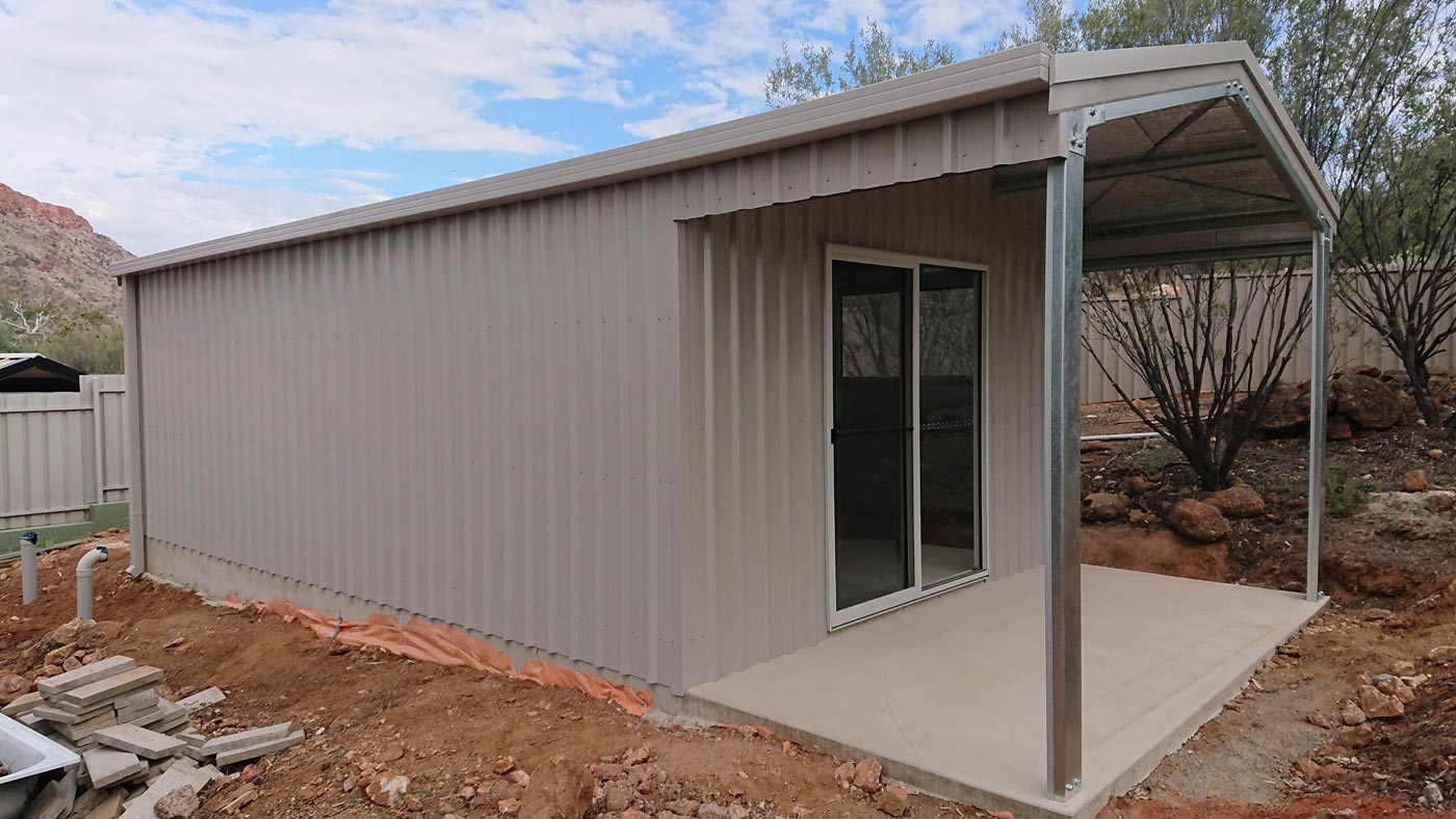A Metal Building With A Porch And Sliding Glass Doors — Alice Sheds & Structures In Ciccone, NT