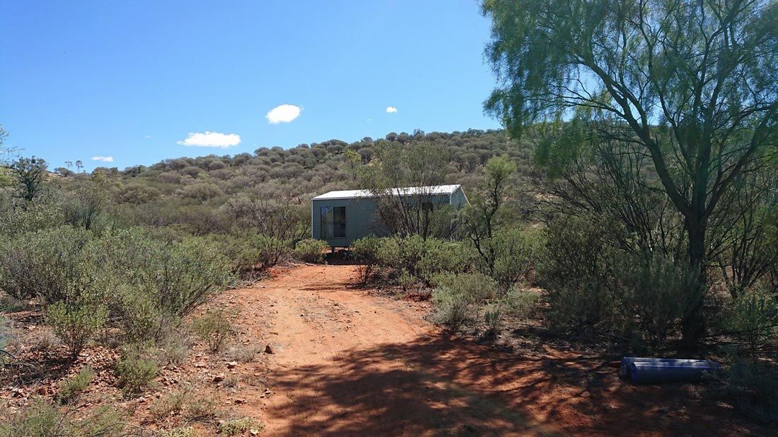 A Trailer Is Parked On The Side Of A Dirt Road — Alice Sheds & Structures In Ciccone, NT