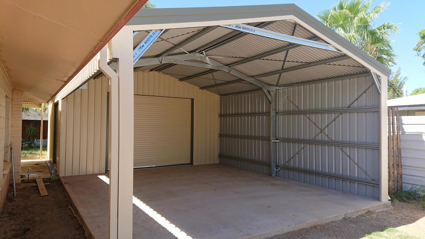 A Garage With A Roof And A Door Is Sitting Next To A House — Alice Sheds & Structures In Ciccone, NT