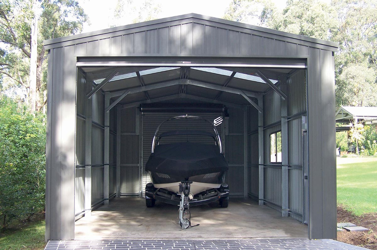 A Boat Is Parked In A Garage With The Door Open — Alice Sheds & Structures In Ciccone, NT