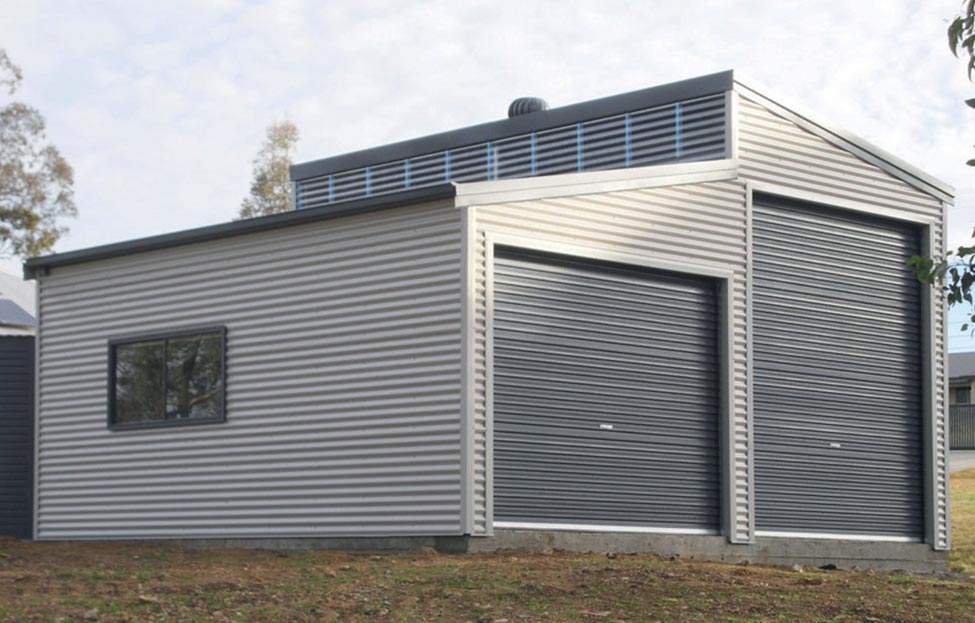 A Garage With Two Garage Doors Is Sitting In The Middle Of A Grassy Field — Alice Sheds & Structures In Ciccone, NT