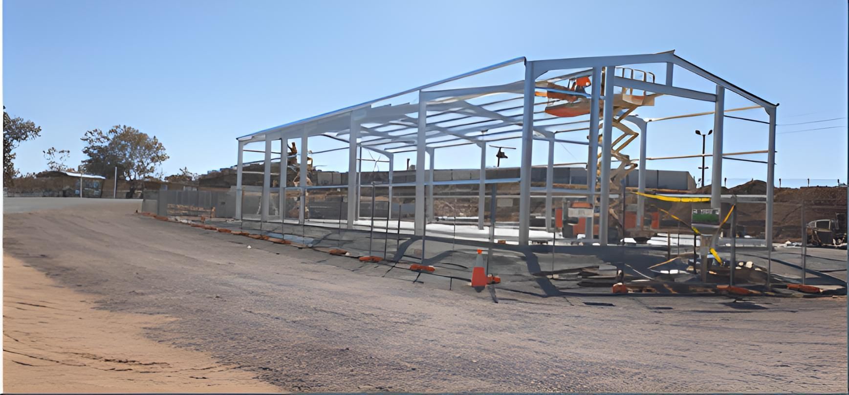 A Large Metal Structure Is Being Built On A Dirt Road — Alice Sheds & Structures In Ciccone, NT
