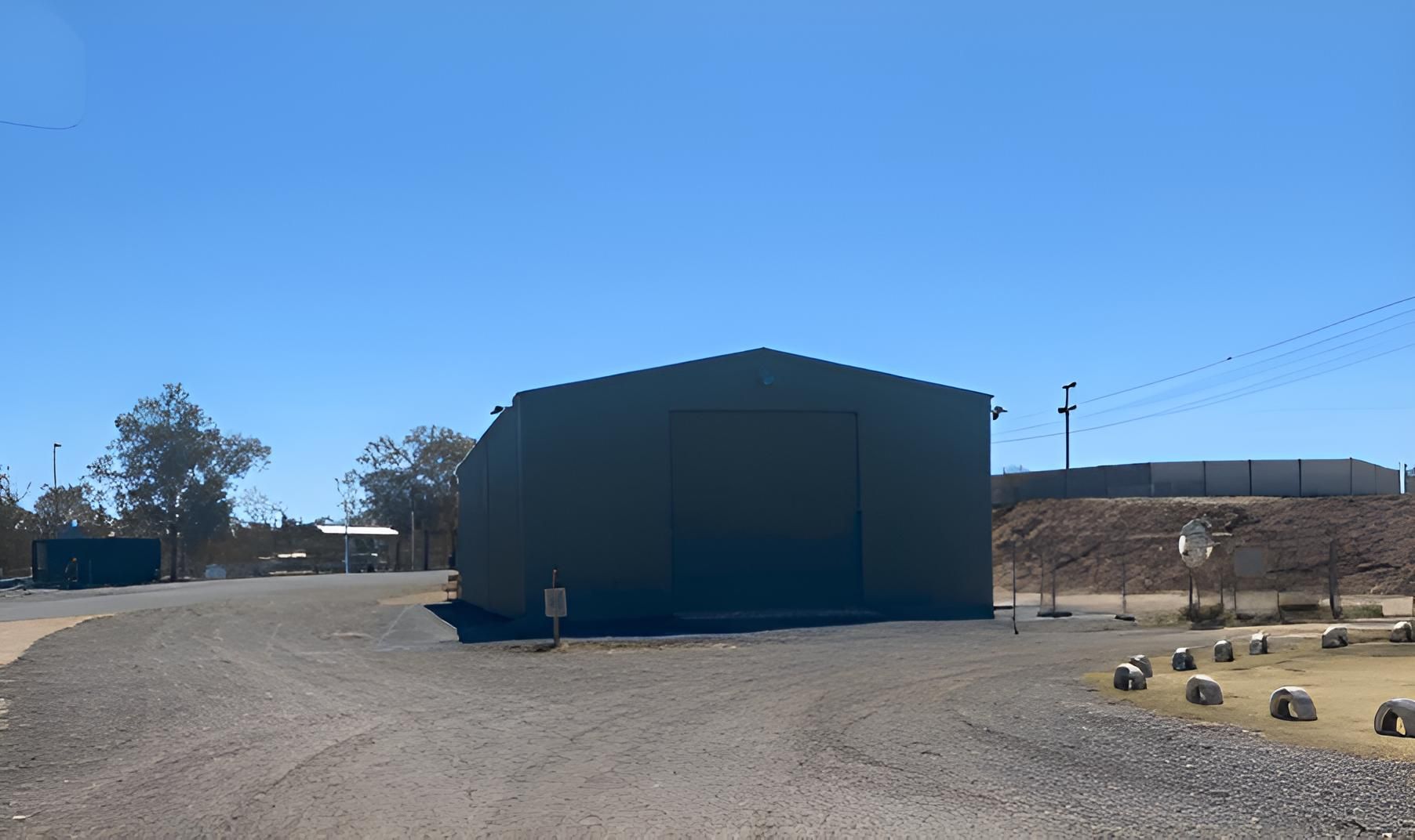 A House With Three White Garage Doors And A Balcony — Alice Sheds & Structures In Ciccone, NT