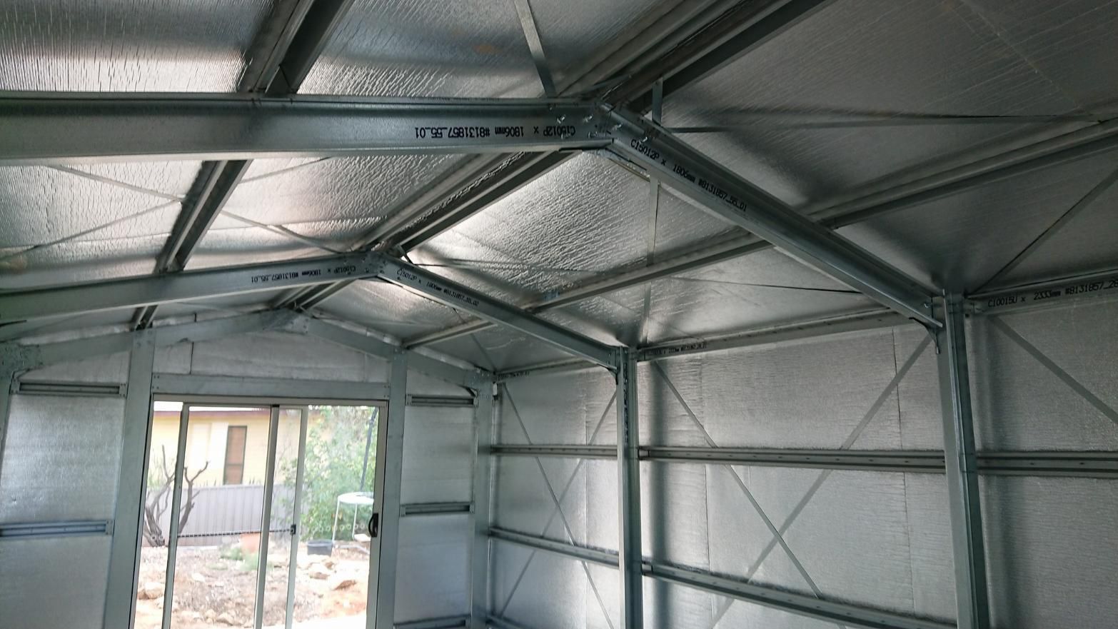 The Inside Of A Metal Building With A Sliding Glass Door — Alice Sheds & Structures In Ciccone, NT