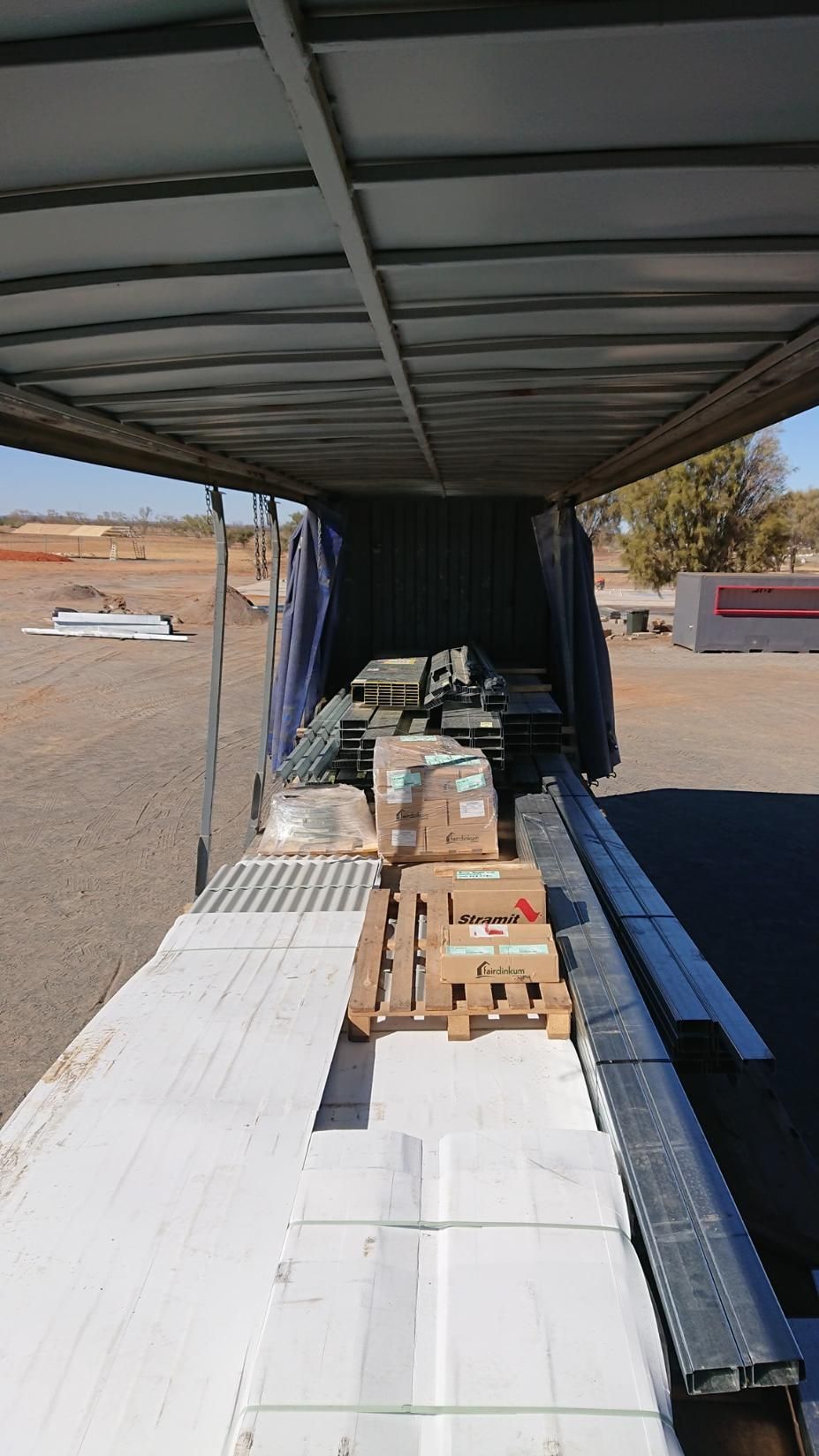 A Truck With Boxes On The Back Of It Is Parked In A Field — Alice Sheds & Structures In Ciccone, NT
