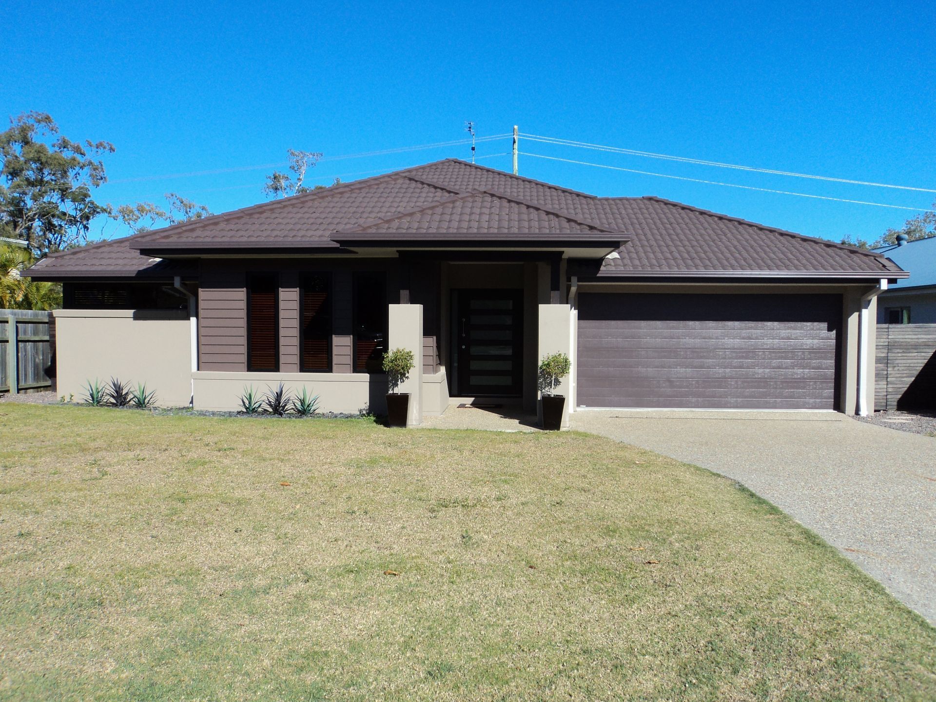Brown-roofed, One-story House With a Garage and Short Front Yard— Coastal Auto Doors & Gates In Palmwoods, QLD