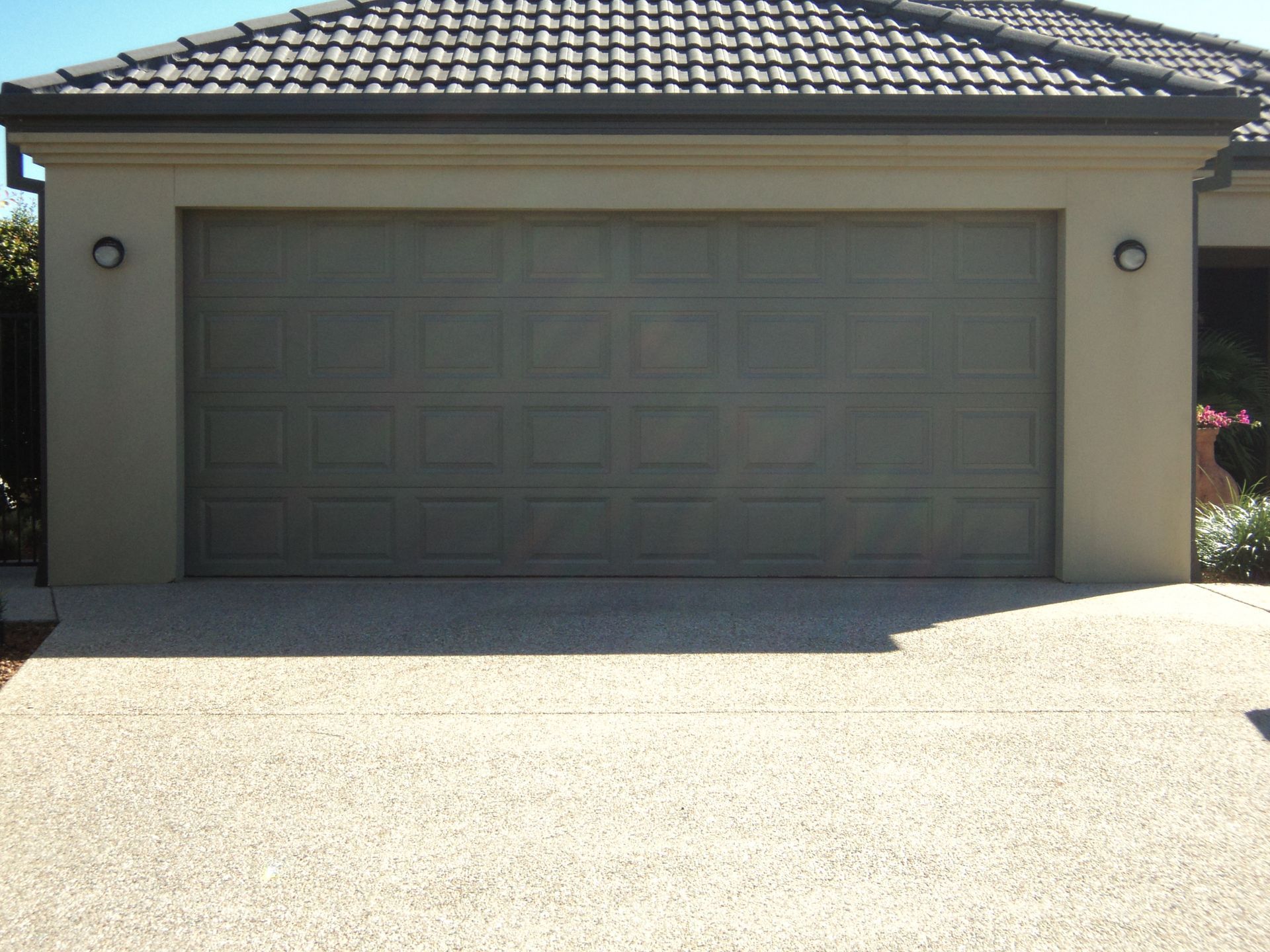Garage With a Gray Door and Beige Speckled Driveway — Coastal Auto Doors & Gates In Noosa, QLD
