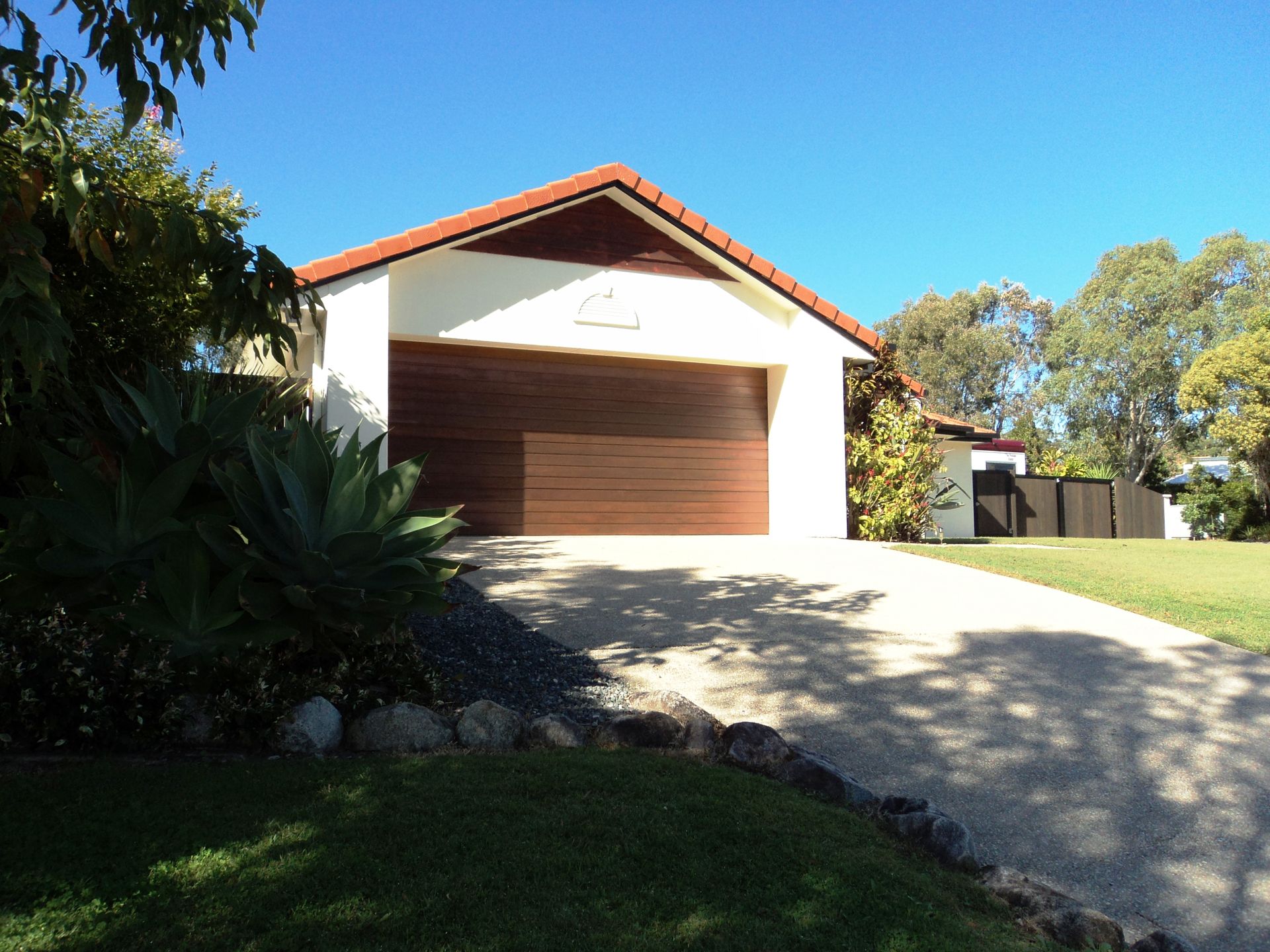 Garage With Brown Door and Roof, on a Sunny Day — Coastal Auto Doors & Gates In Maroochydore, QLD
