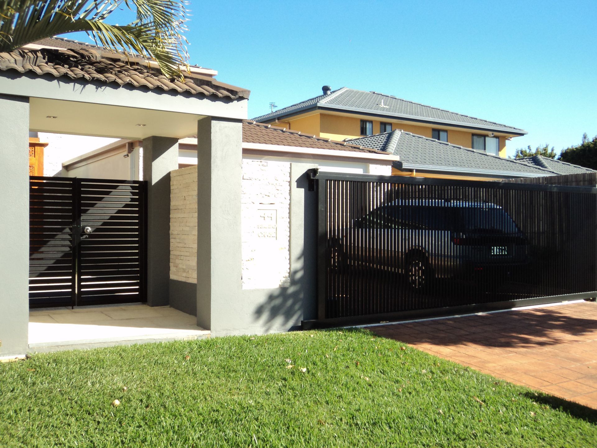 Modern Home Exterior With a Brown Fence and Gate — Coastal Auto Doors & Gates In Palmwoods, QLD