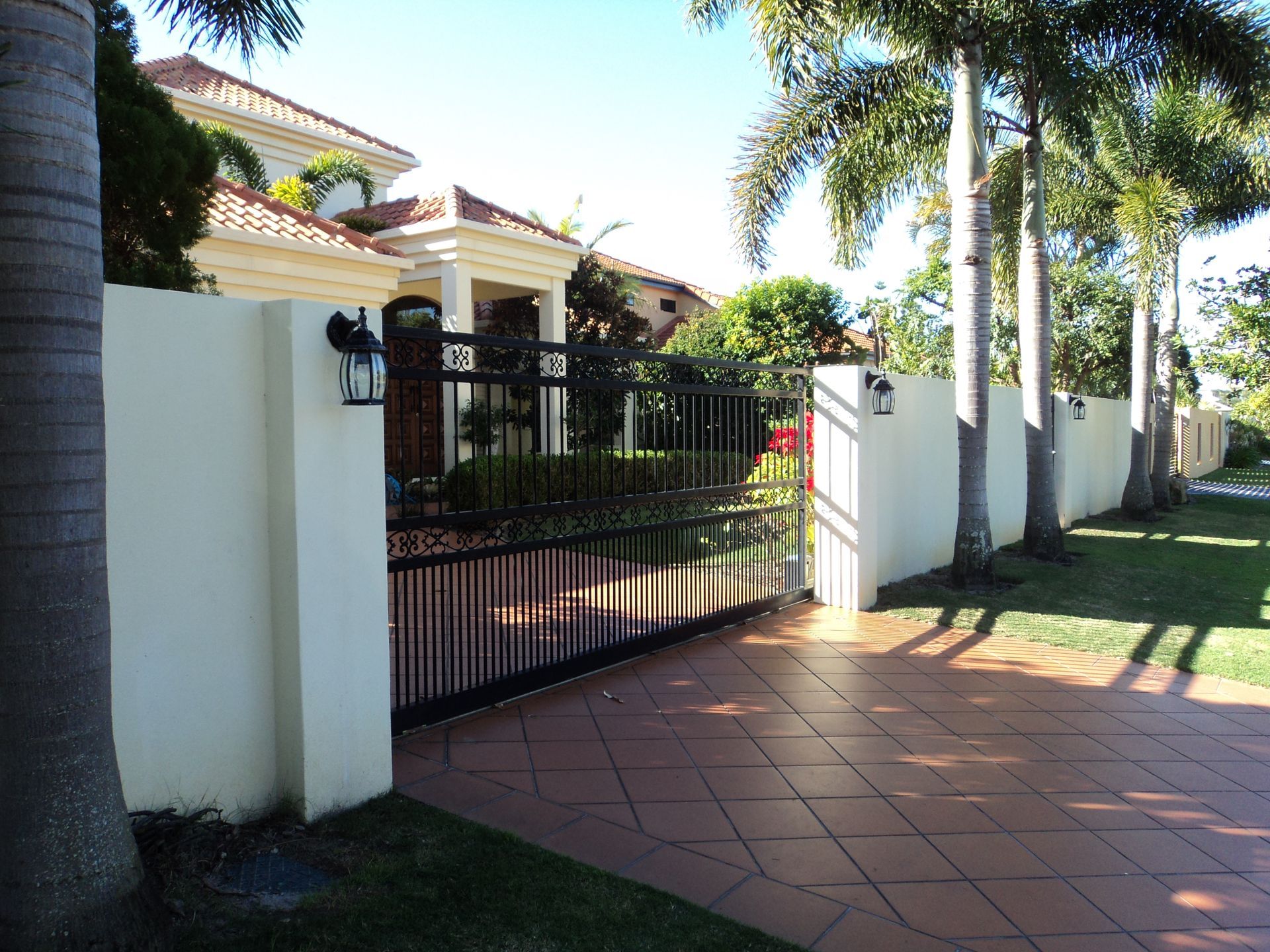 A Large House With a Black Gate and a Tiled Driveway — Coastal Auto Doors & Gates In Palmwoods, QLD
