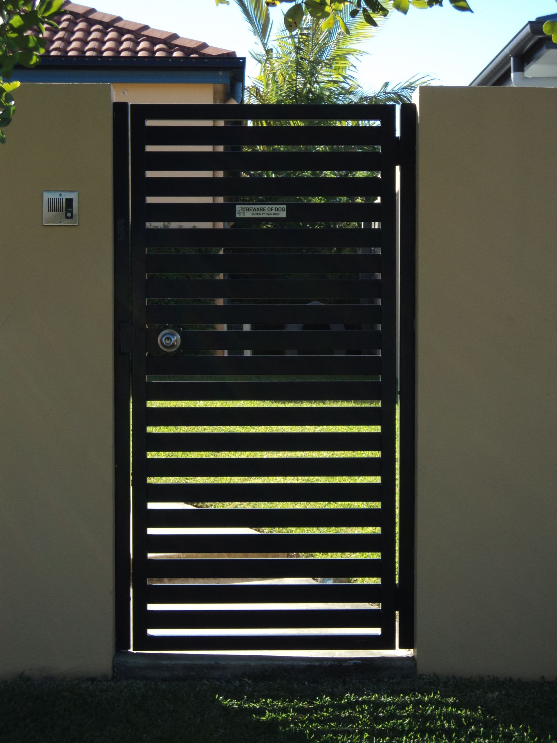 Black Metal Gate in a Beige Wall, Horizontal Slats, Mailbox — Coastal Auto Doors & Gates In Palmwoods, QLD