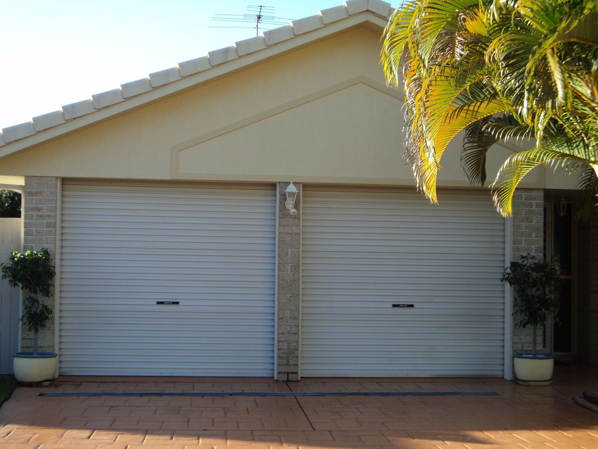 Beige Garage With Two Roll-up Doors — Coastal Auto Doors & Gates In Sunshine Coast, QLD