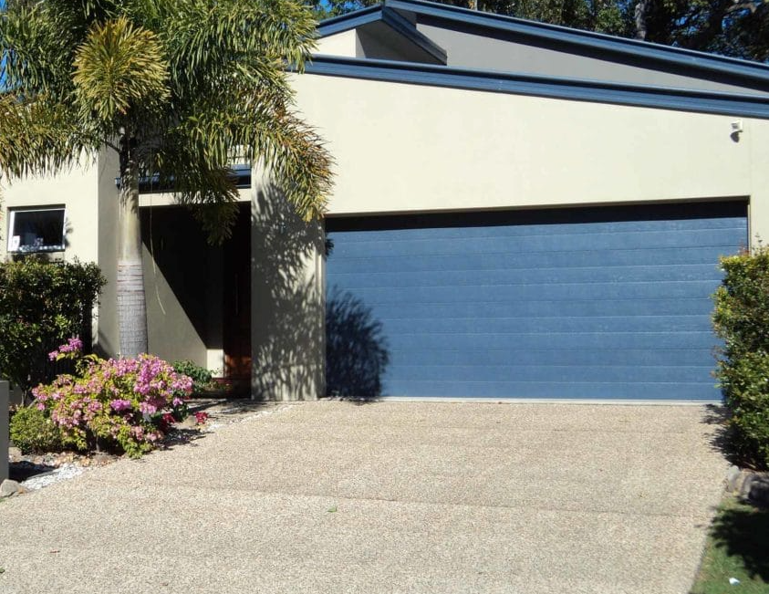 A Garage Door On The Front Of A House — Coastal Auto Doors & Gates In Palmwoods, QLD