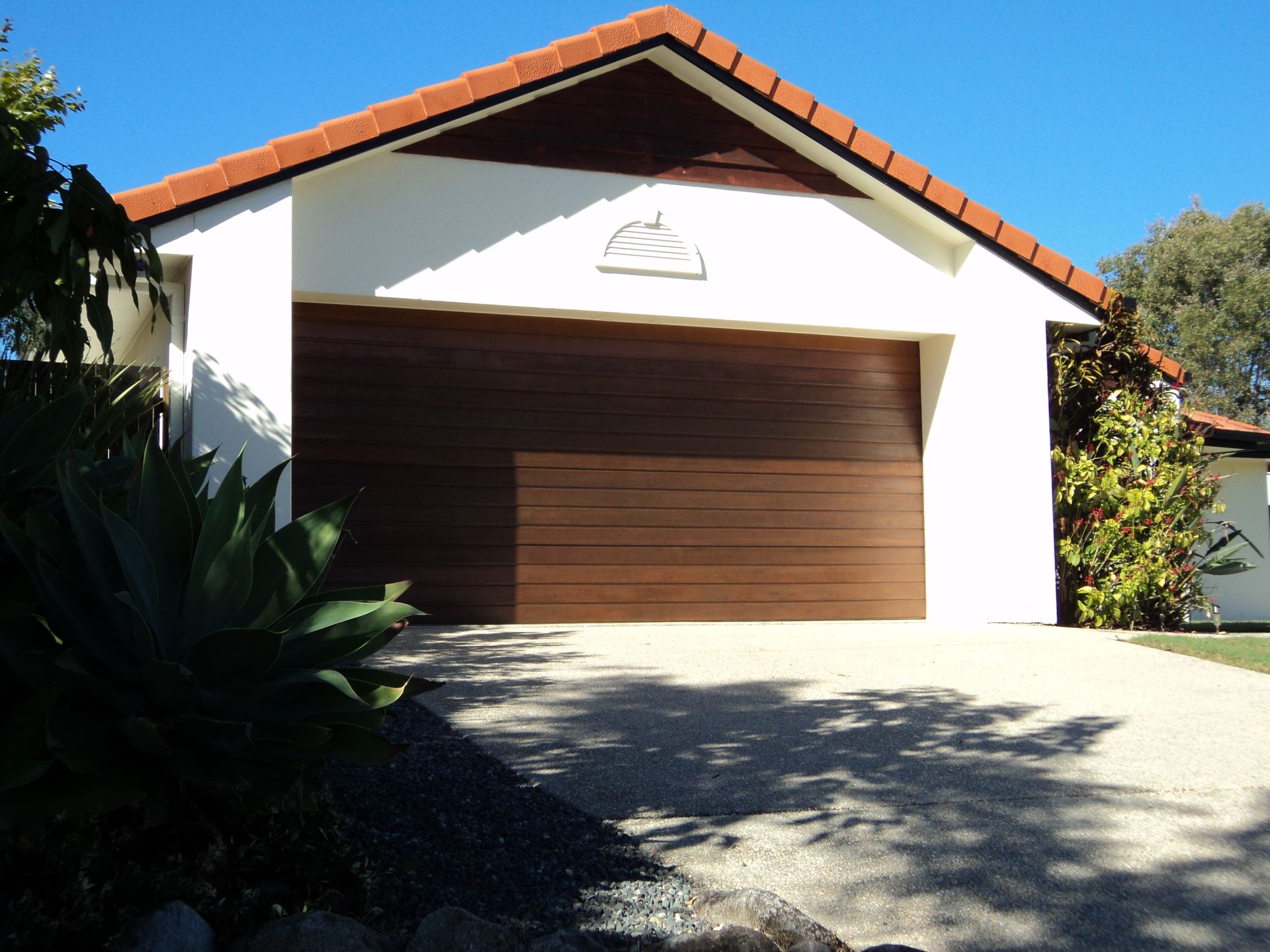 Brown Garage Door on a White House With a Red Tiled Roof — Coastal Auto Doors & Gates In Palmwoods, QLD