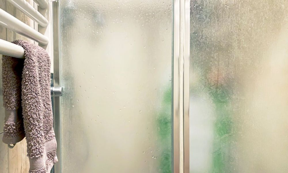 A towel is hanging on a towel rack in a shower stall.