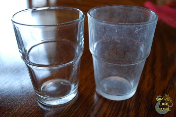 Two clear glasses on a wooden table with simple life at home written on the bottom