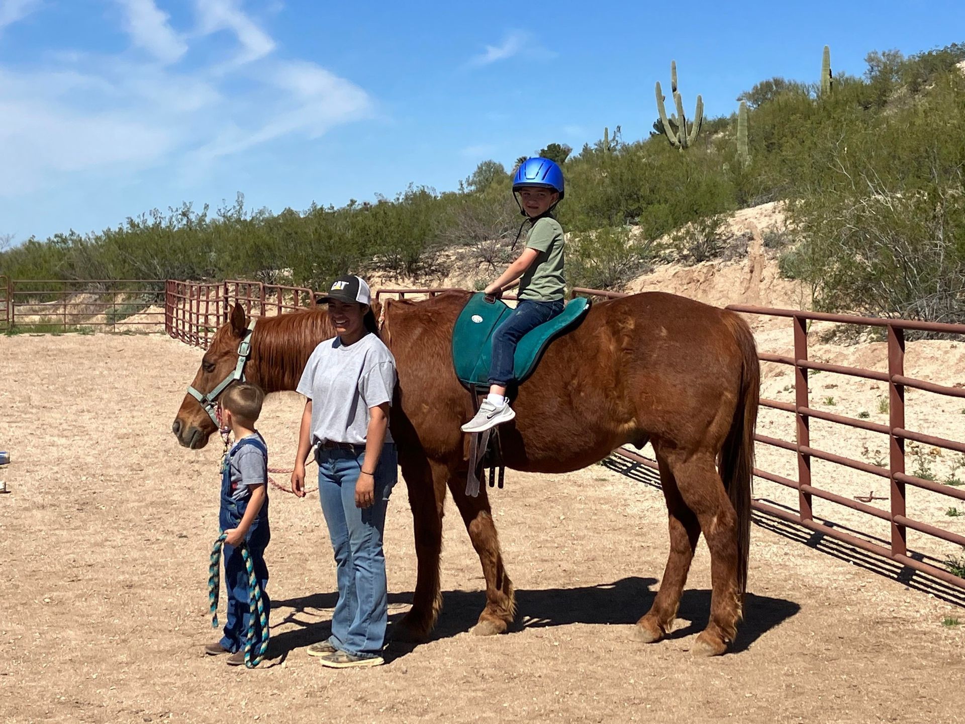 equine equestrian instructor, small child and older child enjoying horseback riding lesson