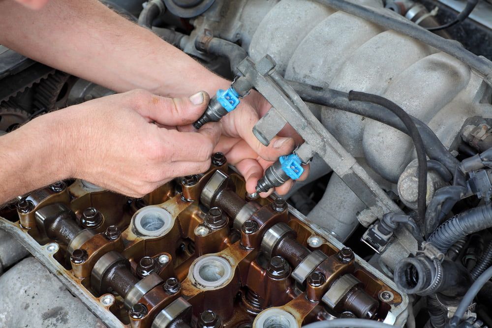 Hands Installing Fuel Injectors Into a Car Engine — Burcher EFI & Service Centre in Orange, NSW