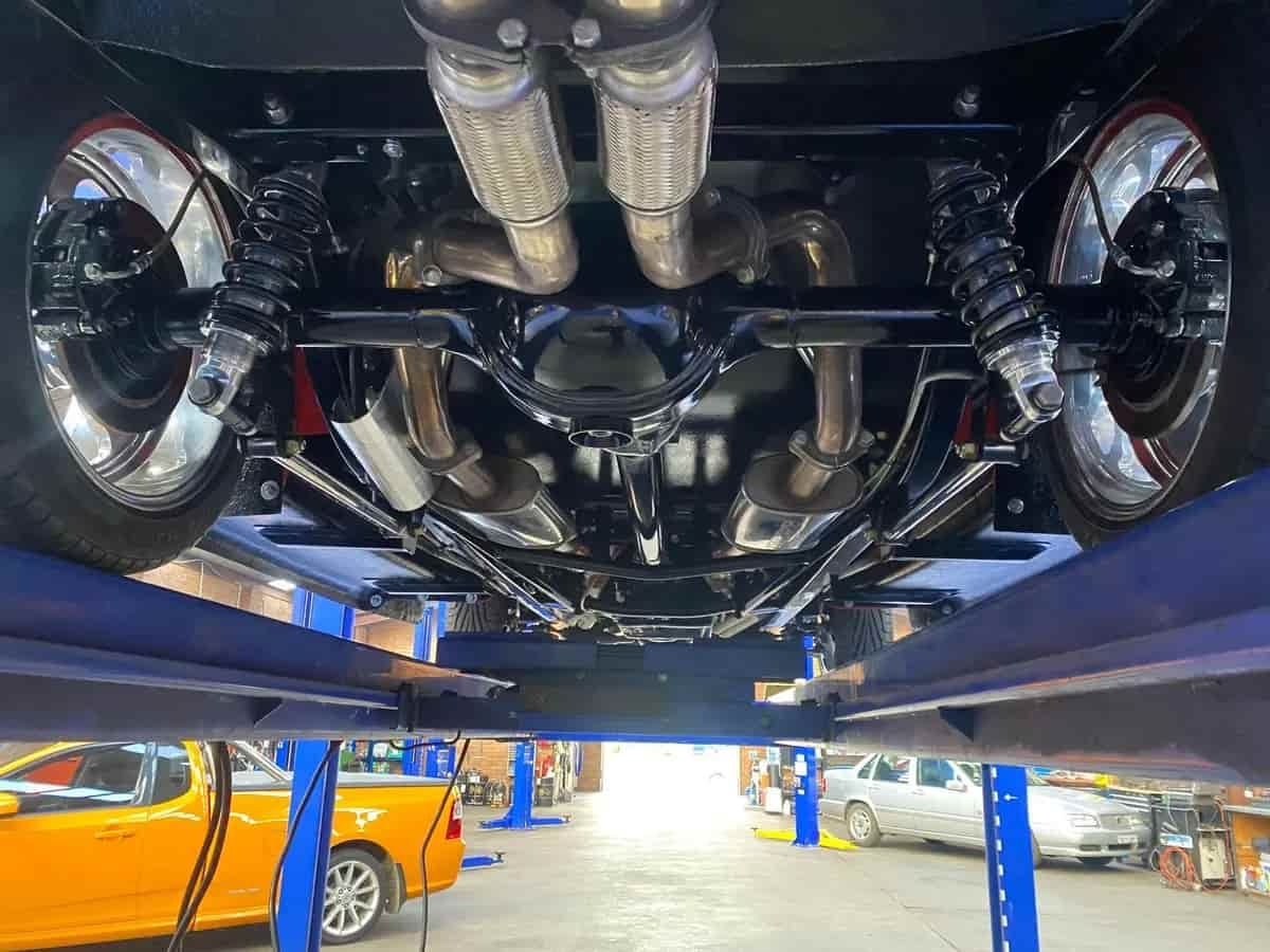 Underside View of a Classic Black Car on a Lift, Showing Exhaust and Suspension — Burcher EFI & Service Centre in Orange, NSW