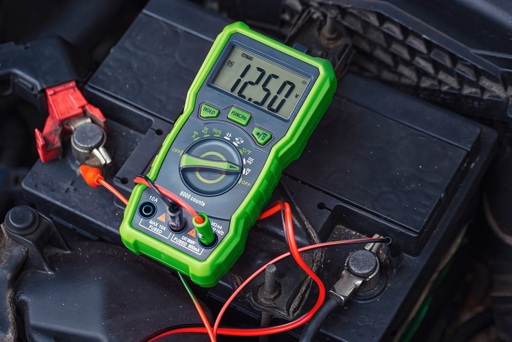 A Green Multimeter With Red and Black Leads Measuring the Voltage of a Car — Burcher EFI & Service Centre in Orange, NSW