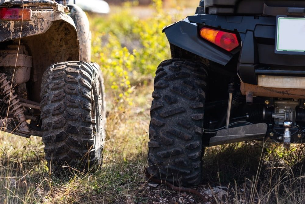 Two All-terrain Vehicles With Large, Treaded Tires Parked Side-by-side — Burcher EFI & Service Centre in Orange, NSW